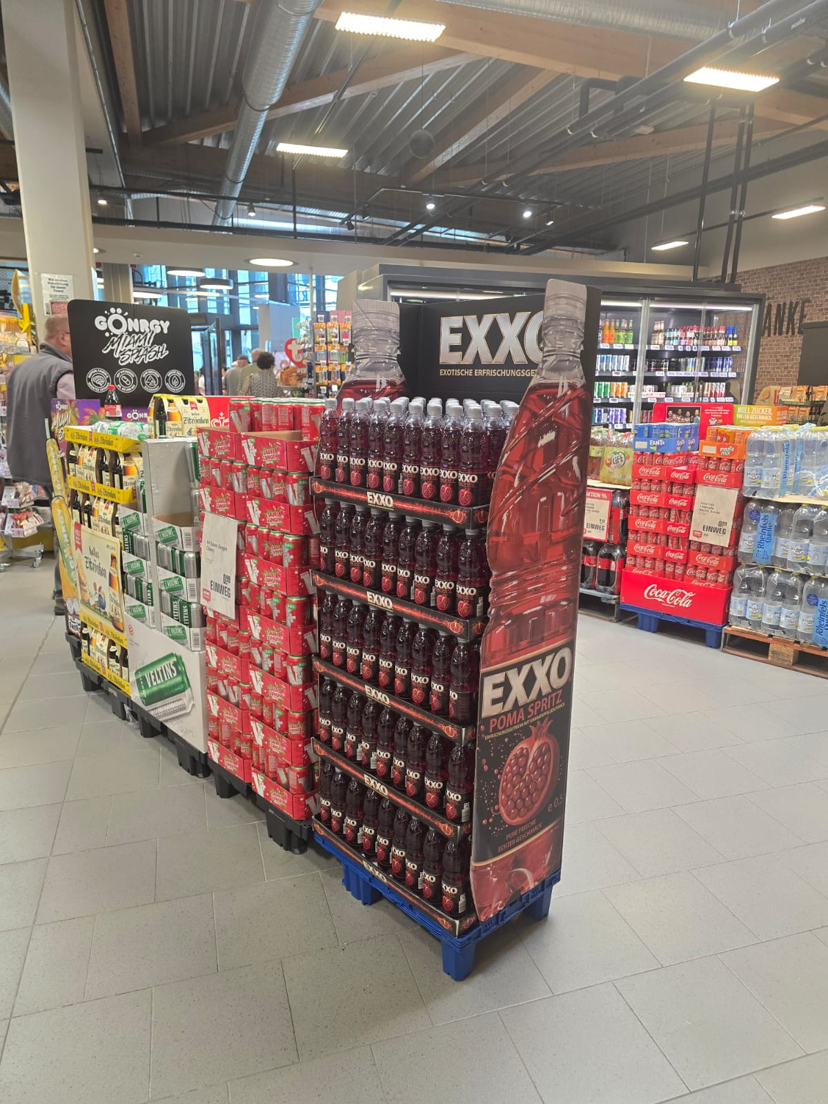 EXXO POMA SPRITZ Palettenplatzierung im Kassenbereich eines Supermarkts